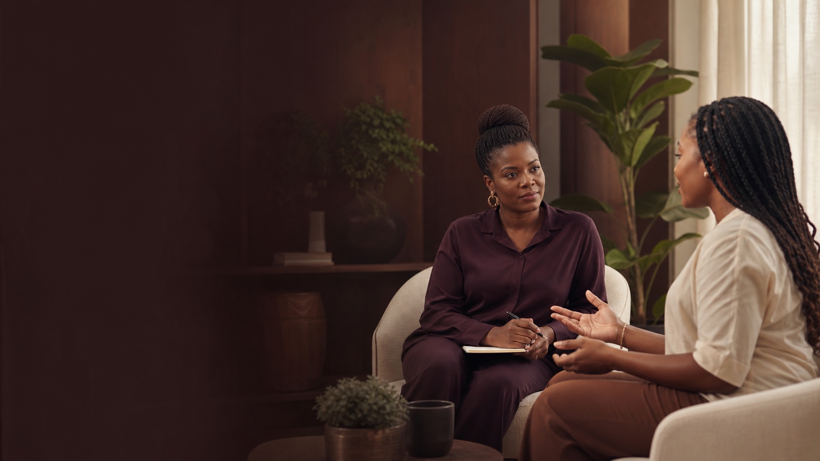 A Black African therapist listening attentively to a client in a calm private session